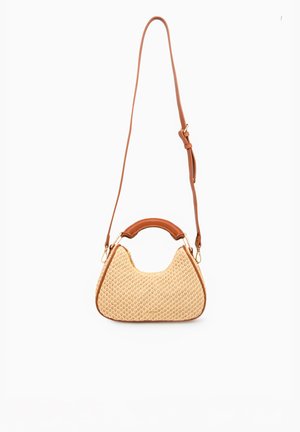 Small crescent-shaped woven beige handbag with brown leather trim, top handle, and adjustable long shoulder strap against white background.
