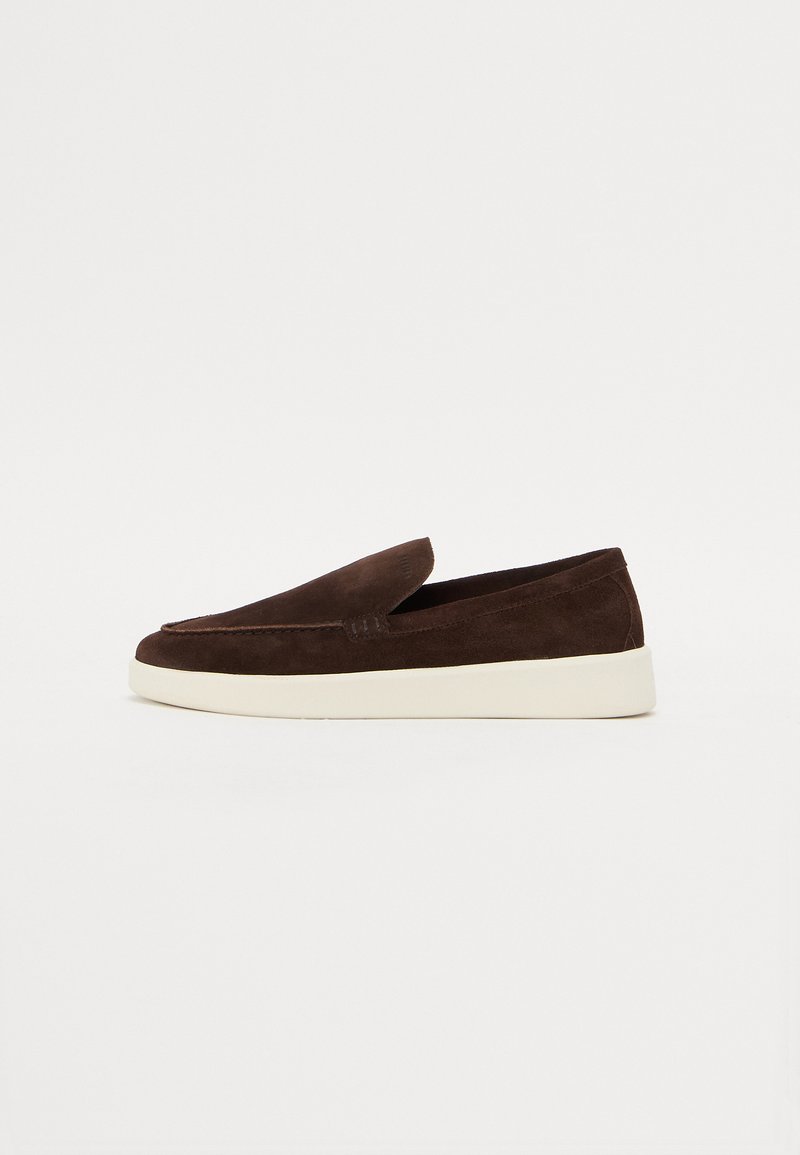 Brune mokasiner i semsket skinn med rund tå og hvit gummisåle. Glatt tekstur og minimalistisk design, med en subtil sømdetalj.
