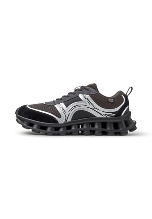 Schwarzer und grauer Sportschuh mit silbernem Wellendesign und gepolsterter segmentierter Sohle, Seitenansicht mit Zuglasche an der Ferse.