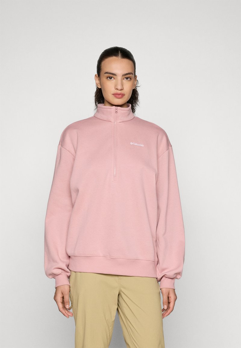 Pullover con cerniera rosa chiaro, colletto alto, spalle basse e polsini a costine. Presenta un piccolo logo bianco sul petto. Tessuto morbido.