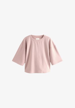 T-shirt en coton rose clair avec des manches courtes et larges, un col rond et une coupe décontractée. Texture lisse sans motifs ni accents visibles.
