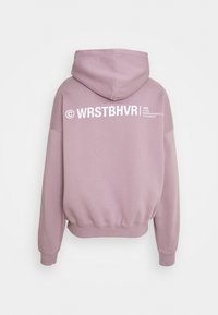 Lila huvtröja med känguruficka, stor huva och ribbade muddarna. Utrustad med vit branding och text på baksidan för detalj.