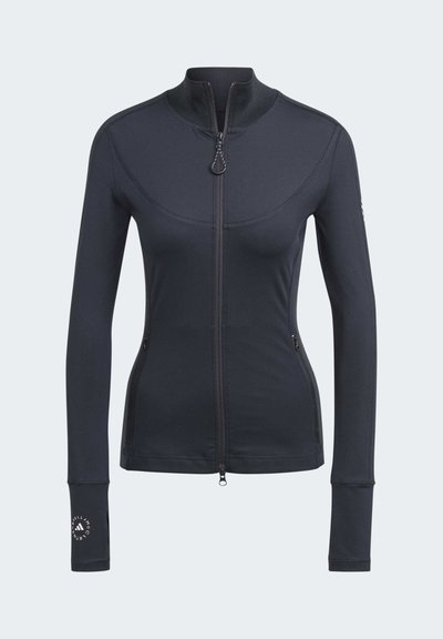 Chaqueta deportiva ajustada de manga larga y cremalleras en negro, con cuello alto, agujeros para los pulgares, bolsillos laterales con cremallera y logotipo en el puño y la mangas izquierda.