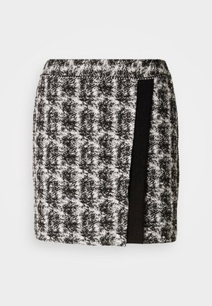 Mustat ja valkoiset hounstooth-kuosiset hameet, joissa on joustava vyötärö, ja sivussa musta kankainen paneeli. Lyhyt pituus, tekstiilinäyte.