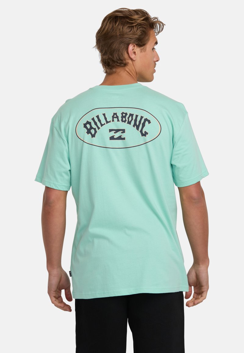 Mint green short-sleeve t-shirt made of cotton, featuring a bold "Billabong" logo on the back with a wave design in black outline.