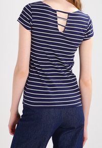 Marineblå stribet t-shirt med korte ærmer og scoop neck, med en dekorativ rygudskæring med krydsende stropper.