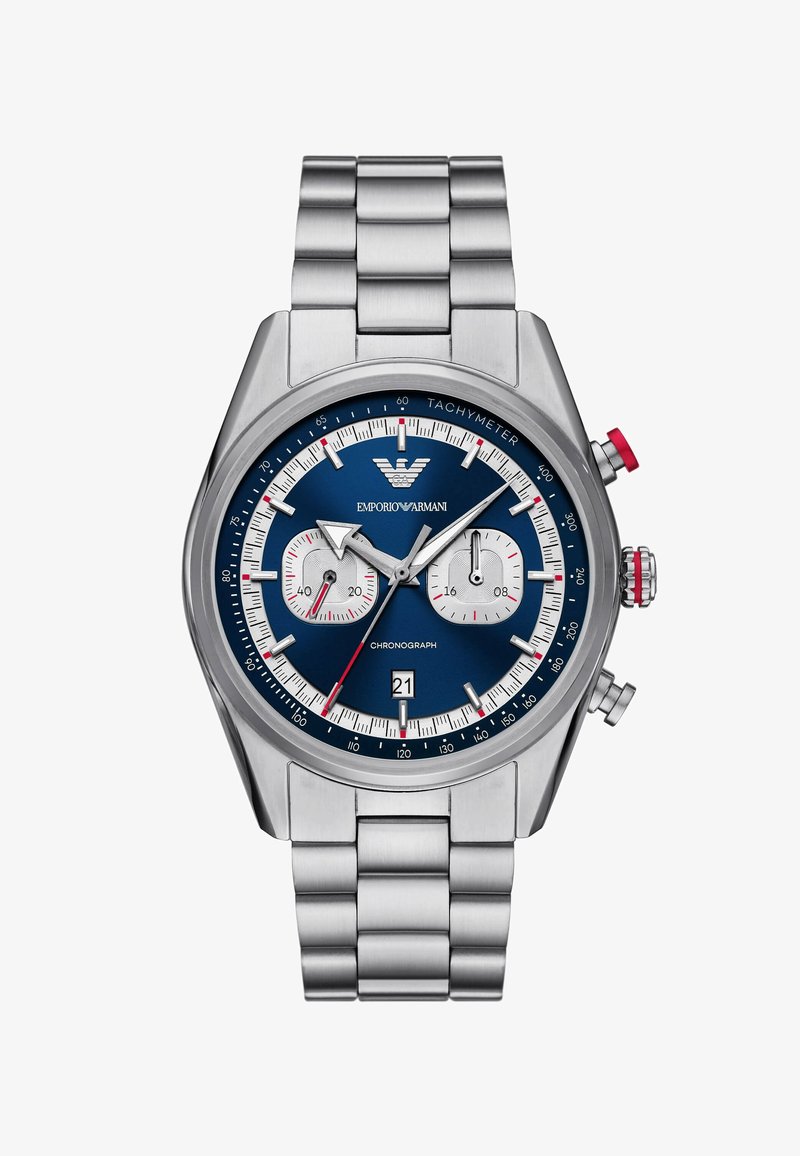 Silverfärgad klocka i rostfritt stål med kronograf, blå urtavla, vita underdials, röda accenter och en tachymeter. Har en datumdisplay och länkarmband.