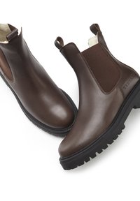 Braune Leder Chelsea-Stiefel mit elastischen Seitenpaneelen, strukturierten Gummisohlen und einer Zugschlaufe für einfaches Anziehen. Entworfen für Komfort und Langlebigkeit.