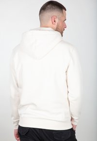 Sudadera crema clara con capucha ajustable, puños y dobladillo acanalados. Fabricada en un tejido suave, presenta un corte relajado y un diseño minimalista.