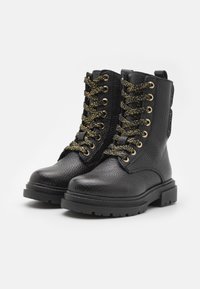 Černé kožené kotníkové boty s texturovaným povrchem, zlatými očky a třpytivými černými tkaničkami. Robustní podrážka s mírným podpatkem.