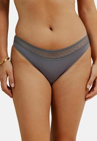 Slip gris avec une bordure en dentelle à la taille, fabriqué à partir d'un matériau lisse avec une texture douce et des détails de conception minimalistes.