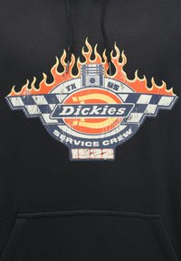 Μαύρο φούτερ με κουκούλα που διαθέτει γραφικό σχέδιο με κόκκινες φλόγες, γαλάζια καρό σημαία και το κείμενο «Dickies Service Crew 1922».
