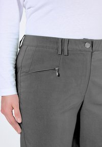 Pantaloni grigi con una texture liscia, dotati di una tasca con zip sul lato destro, passanti per la cintura e chiusura con bottone in vita.