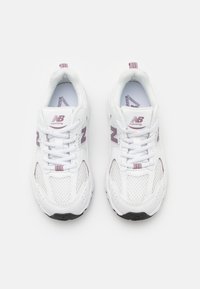Adidași albi pentru alergare, fabricați din plasă și material sintetic, cu accente de violet deschis, șireturi și o talpă din cauciuc negru.