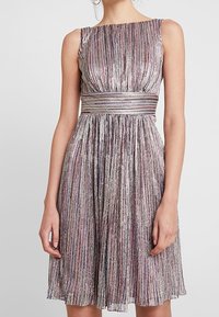 Une robe sans manches au design plissé, avec des rayures métalliques dans des teintes d'argent, de violet et de rose, et une taille marquée.