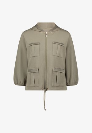 Beżowa kurtka z kapturem na suwak z przodu, cztery kieszenie z patkami i detalem z siateczki, rękawy o długości do łokcia oraz regulowany ściągacz na dole.