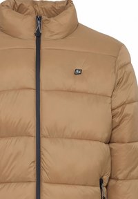 Jachetă puf maro cu guler înalt, închidere cu fermoar și accente negre. Design matlasat cu o textură moale și netedă. Logo pe piept.