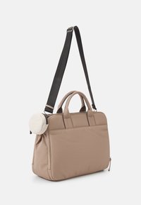 Beige stoftas med en struktureret form, dobbelte top håndtag, justerbar skulderrem og en aftagelig rund beige tilbehørspose.