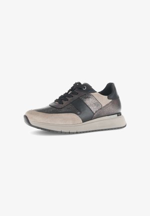 Beige en zwarte sneaker met getextureerde panelen, vetersluiting vooraan en dikke lichtgrijze zool, van opzij getoond tegen een witte achtergrond.