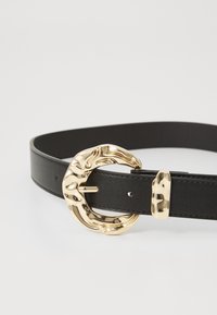 Cinto de couro preto com uma fivela circular texturizada em tom de ouro com um design único e um detalhe em metal a condizer.