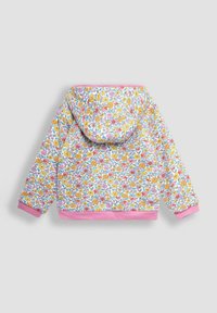 Hnedá bunda s kapucňou s kvetinovým vzorom na bielom základe a živými ružovými, žltými a fialovými kvetmi. Má ružové manžety a lem.