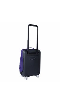 Maleta rígida con cuerpo negro y detalles en púrpura, equipada con un asa telescópica, cuatro ruedas y el logo de EVOC en la parte trasera.