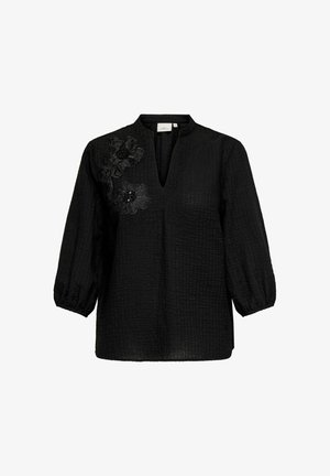 Melna blūze ar trim ceturtdaļas pūkainām piedurknēm, strukturēta auduma, ar V formu izgriezumu priekšpusē un ziedu rotājumiem kreisajā pusē.