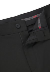 Black trousers made of a textured fabric, featuring a button closure, zip fly, and a HUGO branded interior label in red and gray.