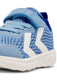 Niebieskie, siateczkowe buty sportowe z białymi akcentami, z paskiem i sznurówkami. Widoczna teksturowana powierzchnia i gumowa podeszwa, podkreślające ich lekką konstrukcję.