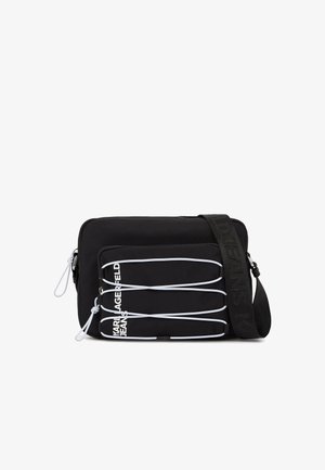 Borsa a tracolla nera con corde elastiche bianche sulla tasca frontale e tracolla regolabile con la scritta "JEANS" in rilievo.