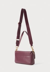 Rectangular dark purple leather shoulder bag with adjustable wide strap and gold-tone hardware, shown against a plain light background.