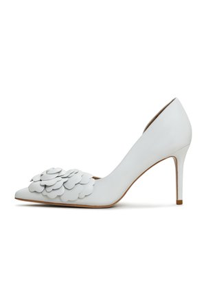 Białe skórzane szpilki z wydłużonym noskiem i warstwowym detalem w postaci aplikacji kwiatowych z przodu, z eleganckim obcasem typu stiletto.