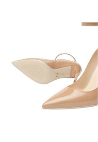 Tacchi alti in pelle patinata color carne con punta affusolata, cinturino alla caviglia e suola in gomma testurizzata. Marchio discreto sulla soletta.