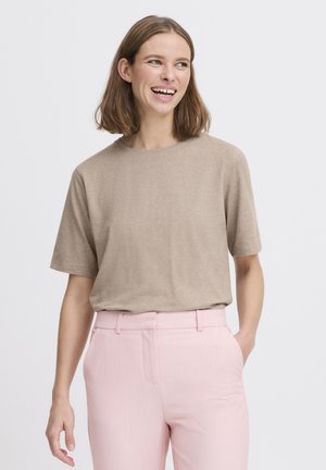 Világosbarna rövid ujjú póló puha anyagból, világos rózsaszín, szabott nadrággal párosítva. Egyszerű kialakítás, kerek nyakkivágás, laza szabás.