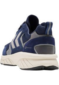 Marinblå idrottssko med en texturerad mocka- och meshöverdel, grå accenter och en krämfärgad sula med ribbade mönster för grepp.