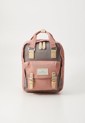 Kompaktowy plecak z różowo-szarej tkaniny, beżowymi paskami z klamrami, podwójnymi górnymi uchwytami, przednią kieszenią na klapie i naszywką z logo „Doughnut”.