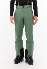Groene skibroek met verstelbare banden, zijzakken met rits, zwarte accenten op de onderbenen en een ontspannen pasvorm voor gemakkelijk bewegen.