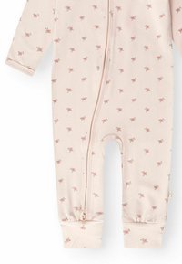 Body bébé rose clair à manches longues, petit motif floral rose, fermeture éclair devant du cou à la cheville, et poignets froncés aux jambes.