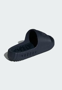 Dark navy slide sandal made of textured rubber. Features a wide open toe design, ridged exterior, and patterned footbed for grip.