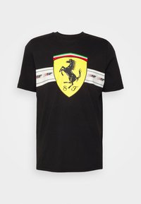 Svart bomullströja med en gul Ferrari-sköldlogotyp, en prancing horse-design och horisontella ränder i vitt och rött över bröstet.