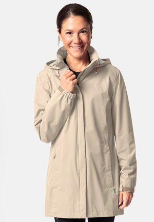Light beige waterproof jacket with a hood, elastic cuffs, and side pockets; features decorative pink accents and branding detail.