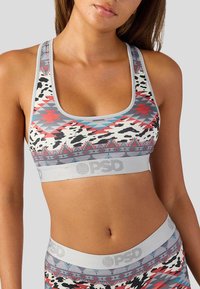 Sportovní podprsenka šedé barvy, s vícebarevnými geometrickými vzory a černobílým potiskem. Obsahuje značkovou elastickou pásku na spodní straně.