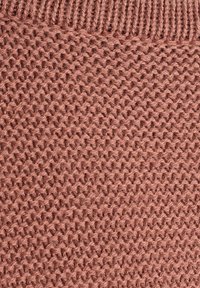 Nahaufnahme von rötlich-braunem Strickstoff mit geripptem Rand und strukturiertem Strickmuster in horizontalen Reihen.