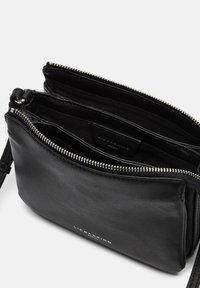 Borsa a tracolla in pelle nera con chiusura a zip, dotata di scomparti interni multipli e una finitura texture. Logo impresso sulla parte anteriore.