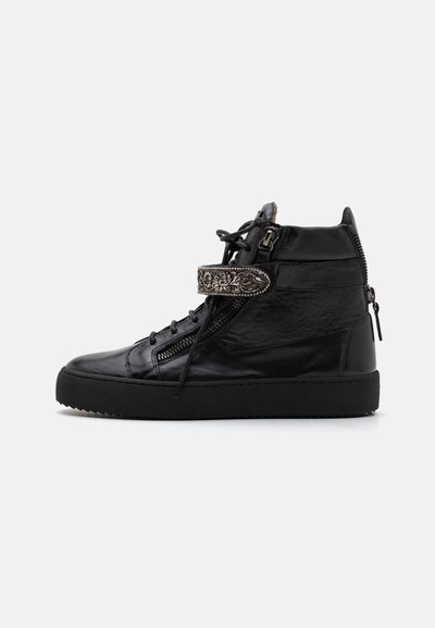 Baskets montantes noires en cuir, dotées de zips, d'un système de laçage et d'une sangle décorative avec des détails en relief. Semelle en caoutchouc.