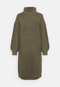 Stickad klänning i olivgrön med hög krage, sänkt axel och långa, voluminösa ärmar. Texturerad, ribbad tyg med avspänt snitt.