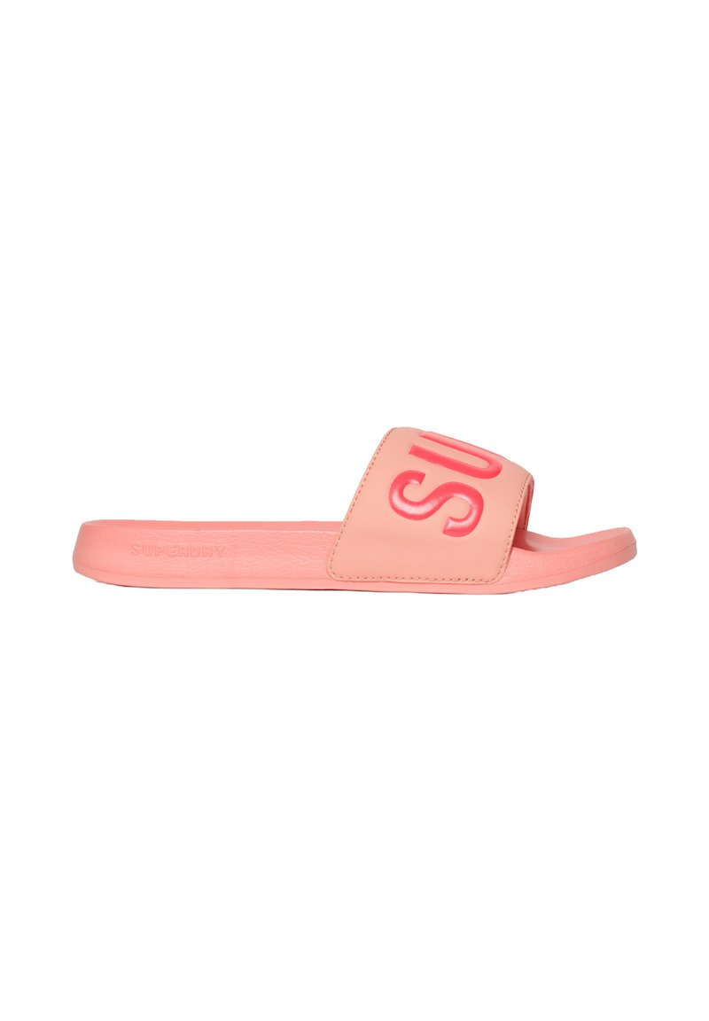 Tongs en caoutchouc rose avec une large sangle arborant un logo en relief. Semelle plate offrant un design facile à enfiler. Texture lisse, detailing minimal.