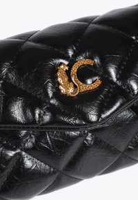 Borsa a tracolla nera trapuntata con un prominente emblema dorato di due leopardi intrecciati con una lettera 'C' stilizzata.