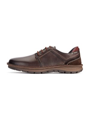 Zapato de vestir marrón de cuero con cordones, costuras visibles, suela de goma y tacón bajo, mostrado de perfil sobre fondo blanco.