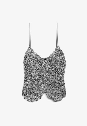 Schwarzes und weißes gestricktes Top mit dünnen Trägern, das ein gewelltes Randdesign und ein strukturiertes Muster aufweist.